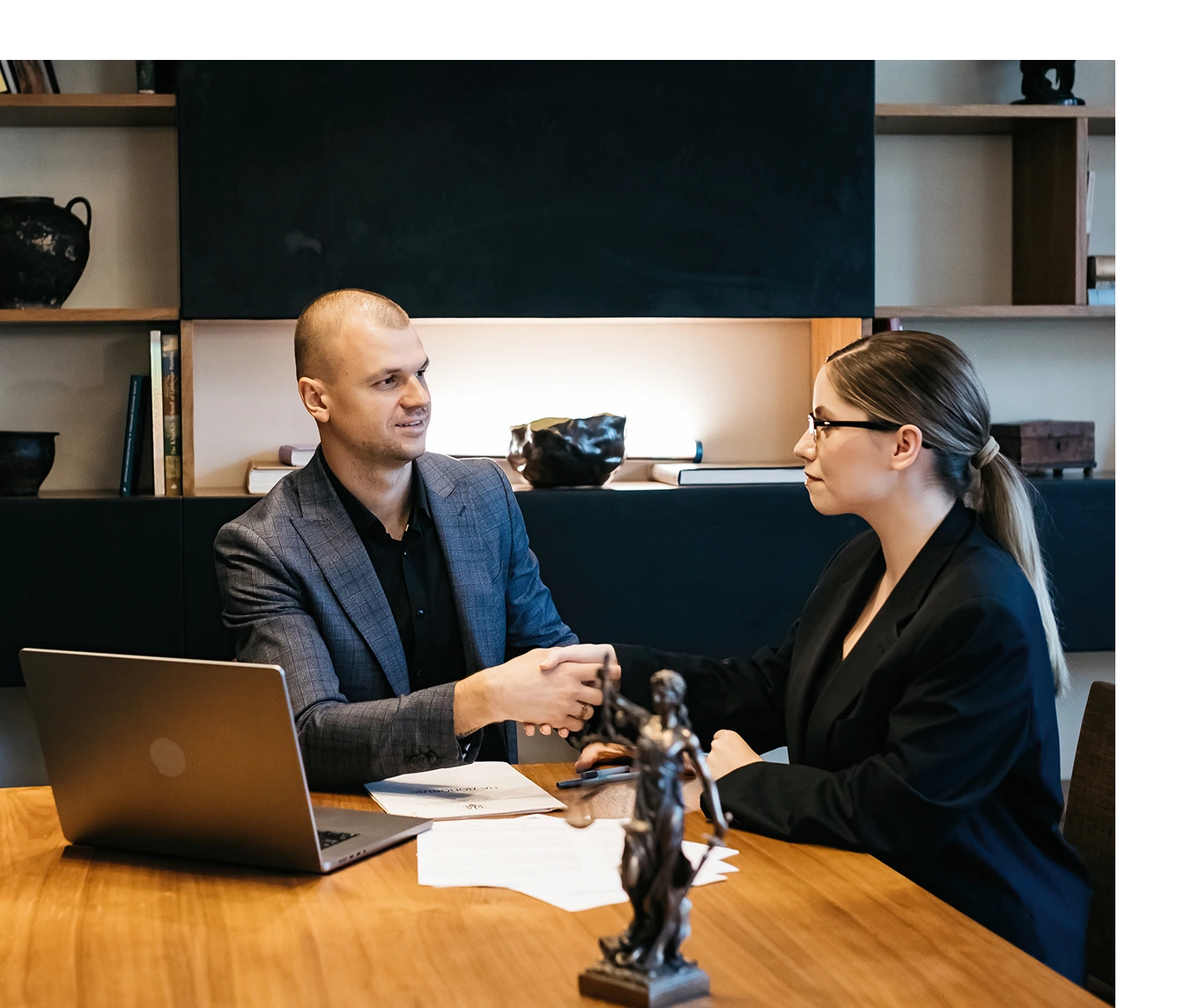 Colleagues shaking hands at desk