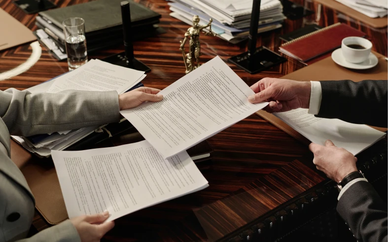 Hands passing legal documents in office