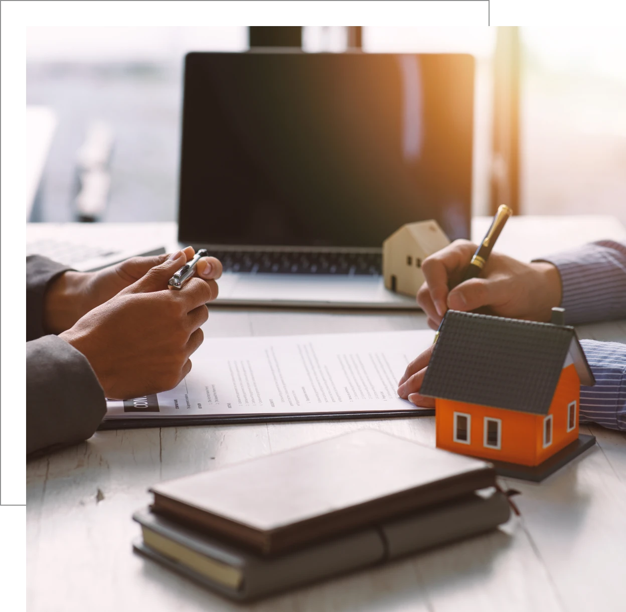 Real estate contract signing with model house